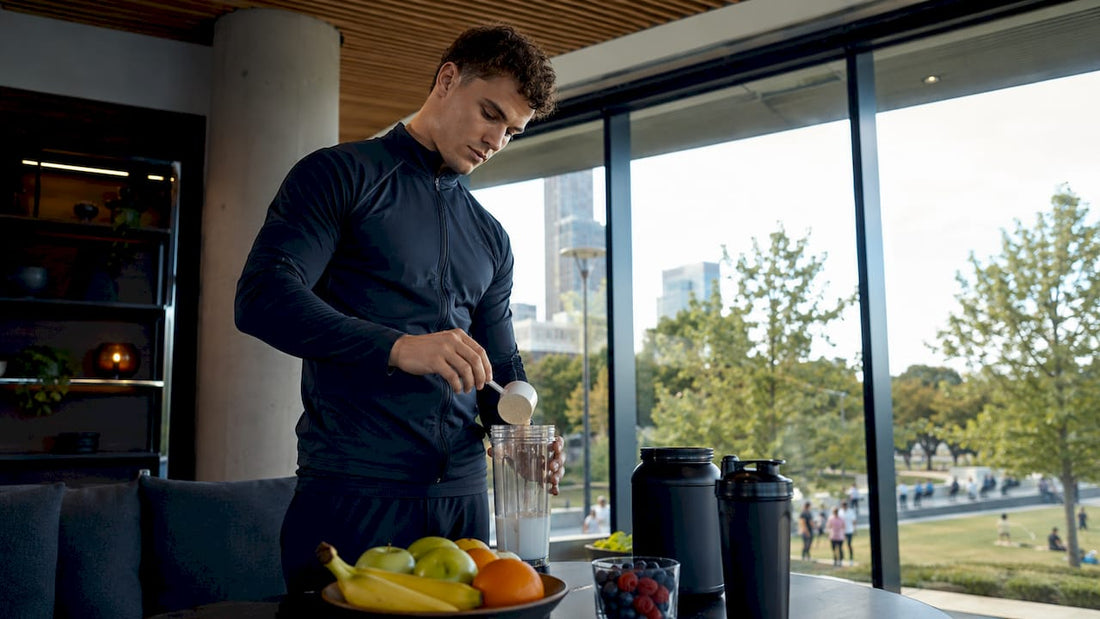 Ein Sportler bereitet sich in der Küche einen Eiweißshake zu.
