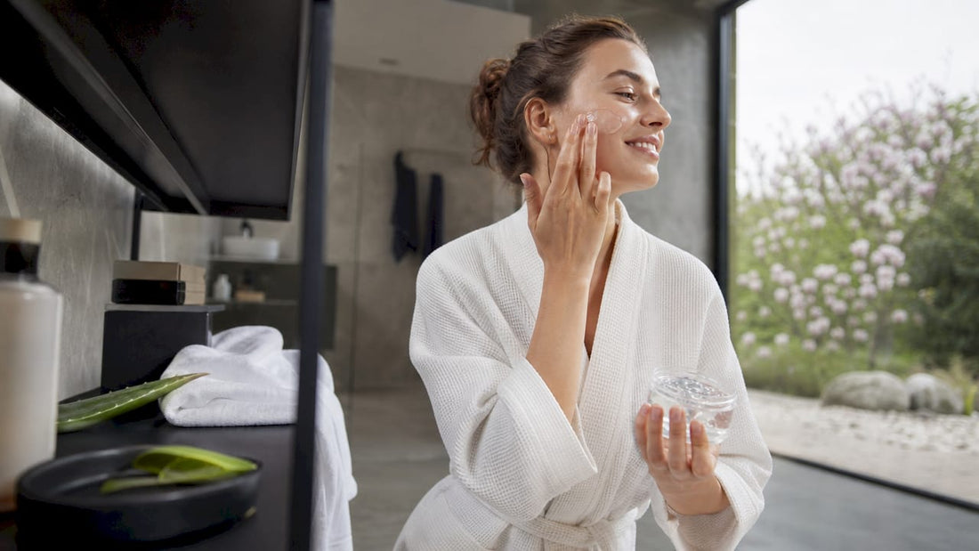 Eine Frau trägt frisches Aloe-Vera-Gel zur Pflege ihrer Haut auf.